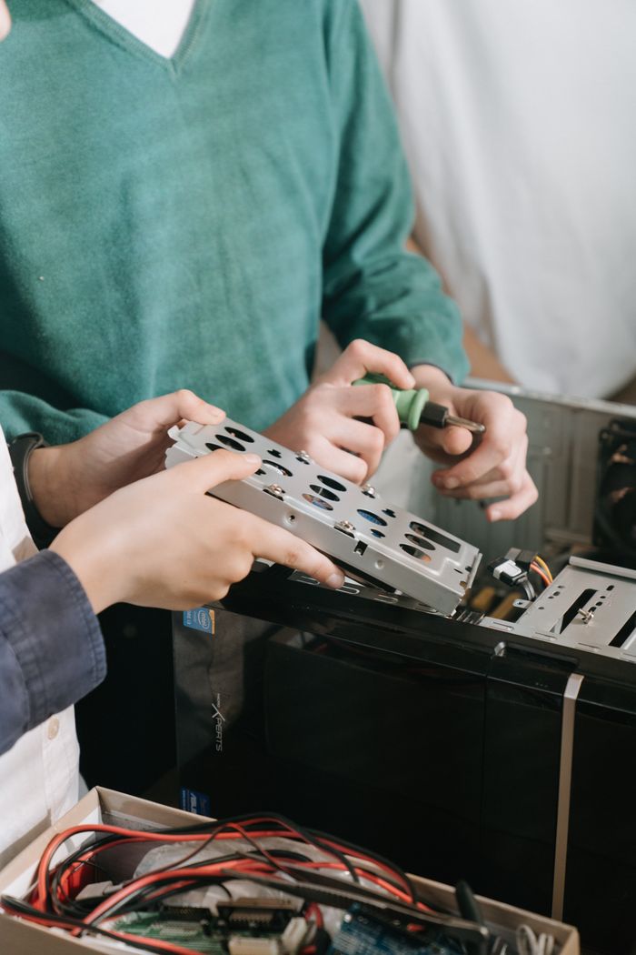 Crafting Captivating Headlines: Your awesome post title goes here Close-up of technicians repairing computer hardware with tools, focusing on hands and equipment.