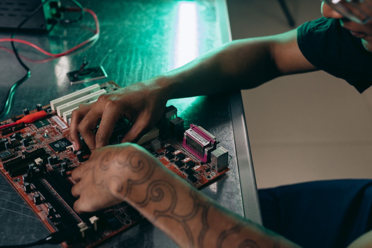 The Art of Drawing Readers In: Your attractive post title goes here Close-up of person assembling a computer motherboard, showcasing a tattooed arm and tech innovation.