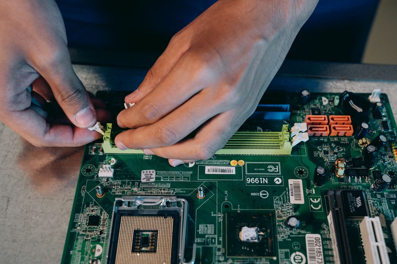 Mastering the First Impression: Your intriguing post title goes here Hands carefully assembling a computer motherboard, showcasing technical craftsmanship in electronics.